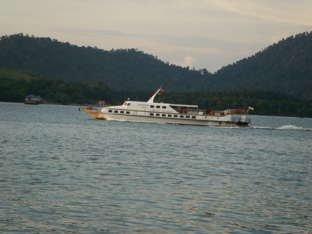 a boat sailing on the water with trees in the background