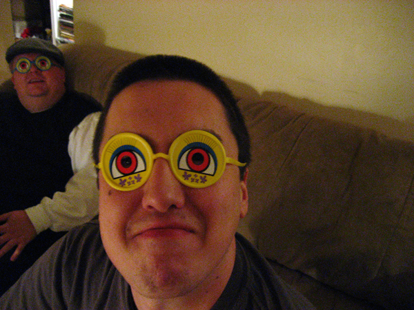 man with two yellow circles in his eyes and another person behind him