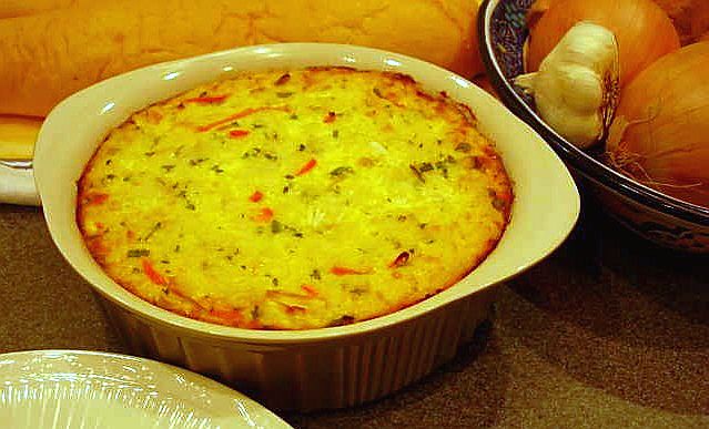 a table with a dish of quiche and vegetables