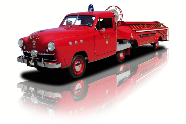 a red fire truck parked on top of a white surface