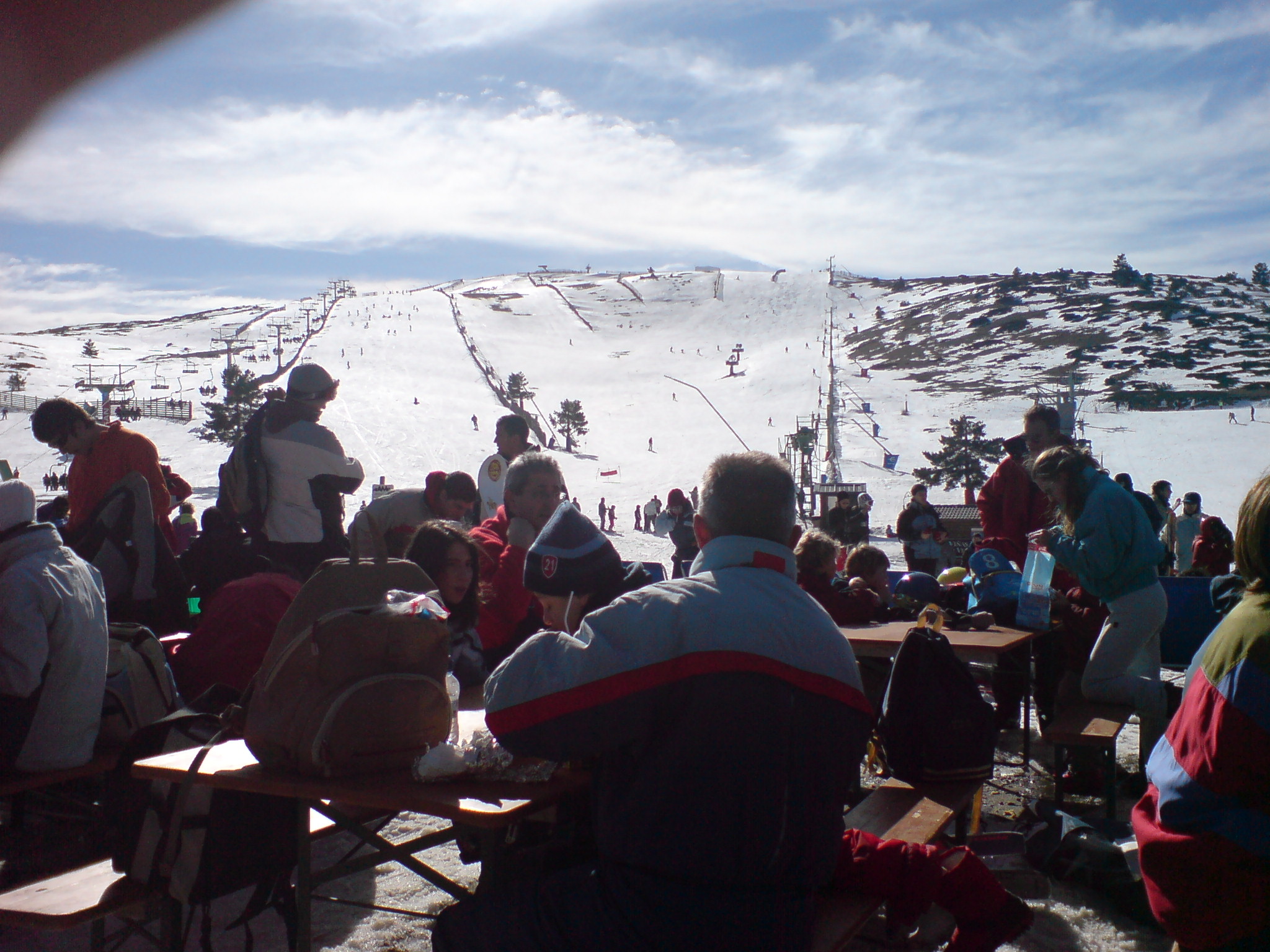 many people at the top of the mountain waiting for a lift