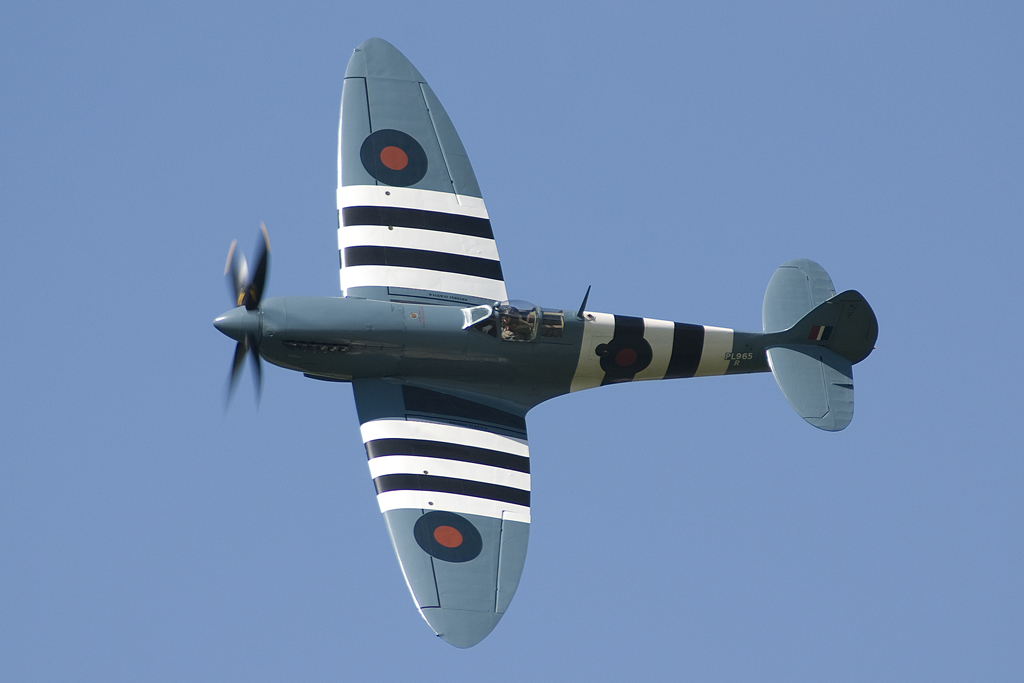 an old style airplane in flight against a blue sky