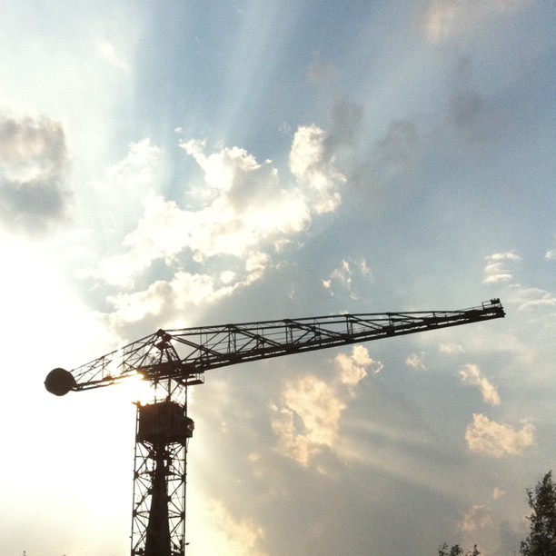 a crane is silhouetted against the sun set