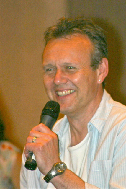a man holds a microphone and looks to the side