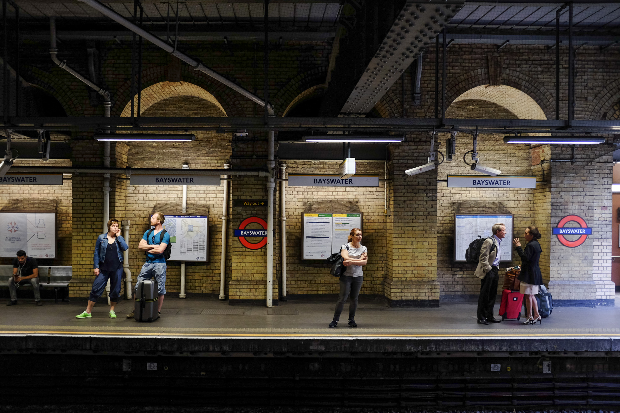 people waiting on the train platform at the station