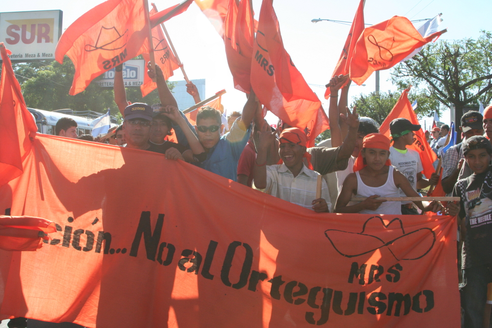 a group of people holding orange flags during a protest