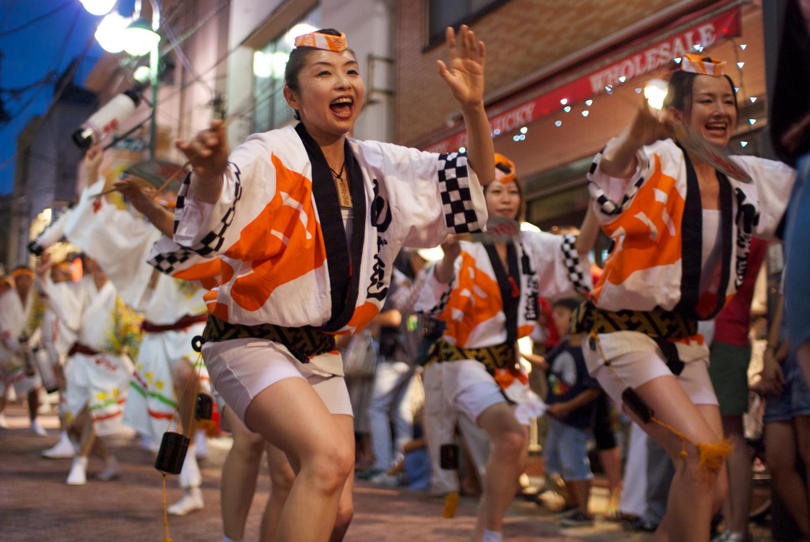 several people performing traditional dance on a city street