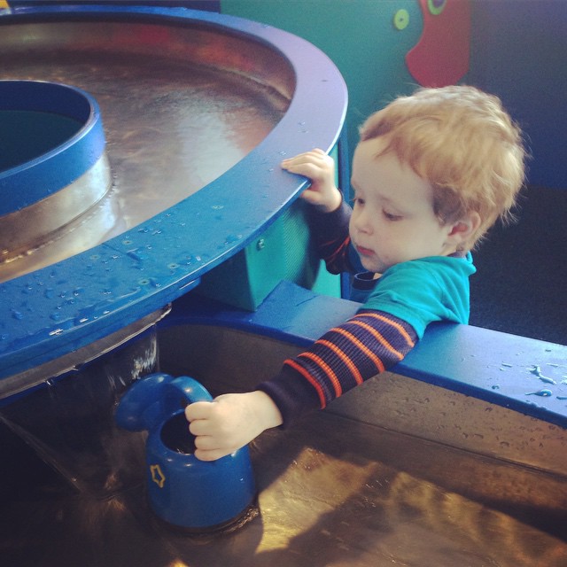 a toddler at a play area trying to climb