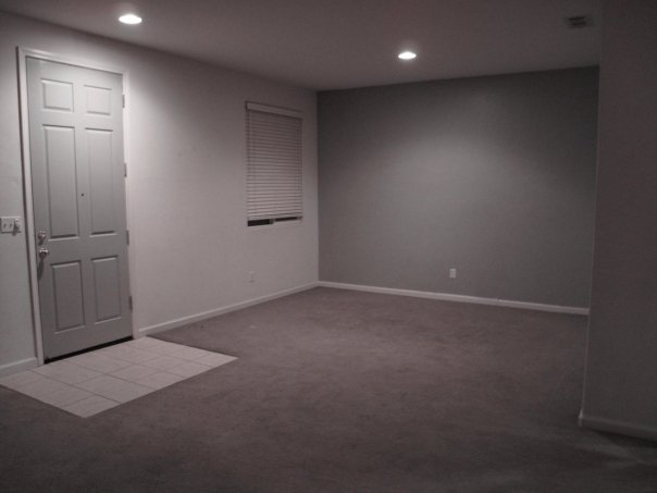 empty white room with door in middle, and tiled floor