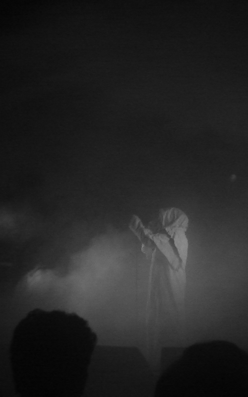 a man singing into a microphone on top of a stage