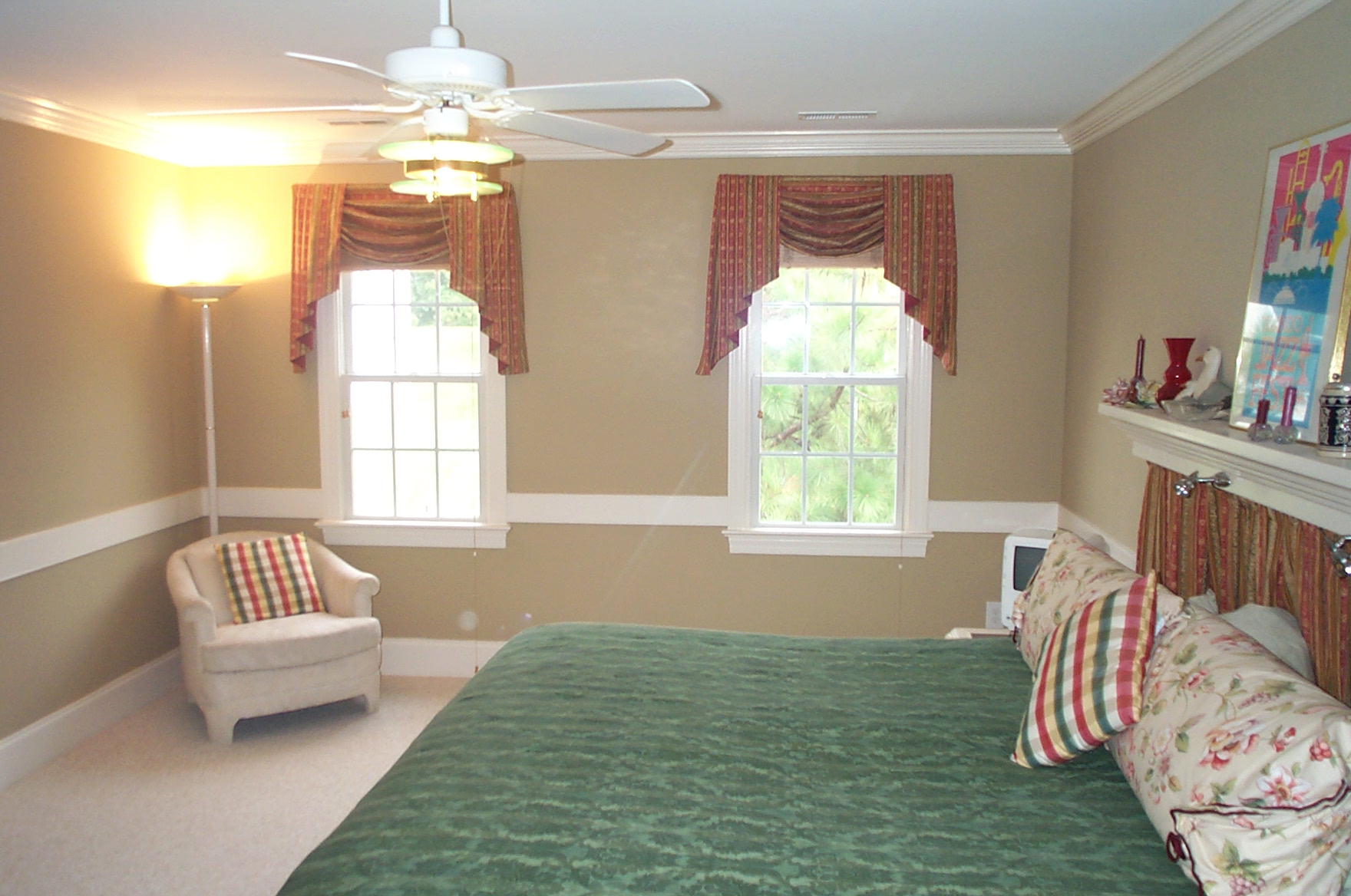 a bedroom with a green bed and white furnishings