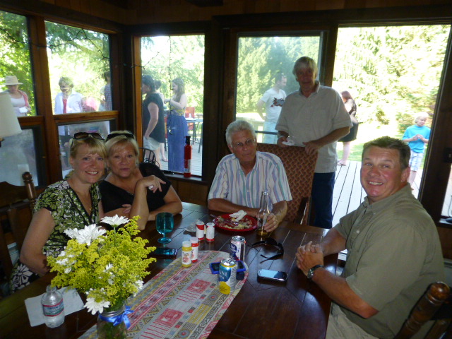 some people at a table with drinks smiling for a po