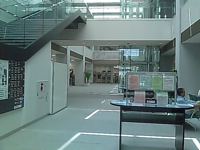 a hallway with an open area and stairs above