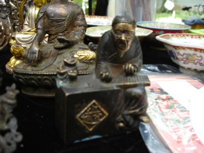 bronze figurines and other antiques sit on a black table