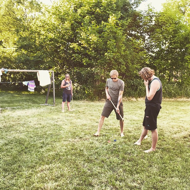 there are two people playing with sticks in the yard