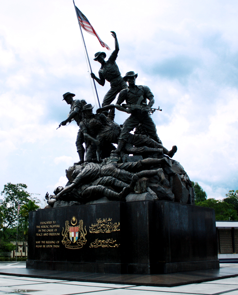 the bronze statue has many figures and a flag flying