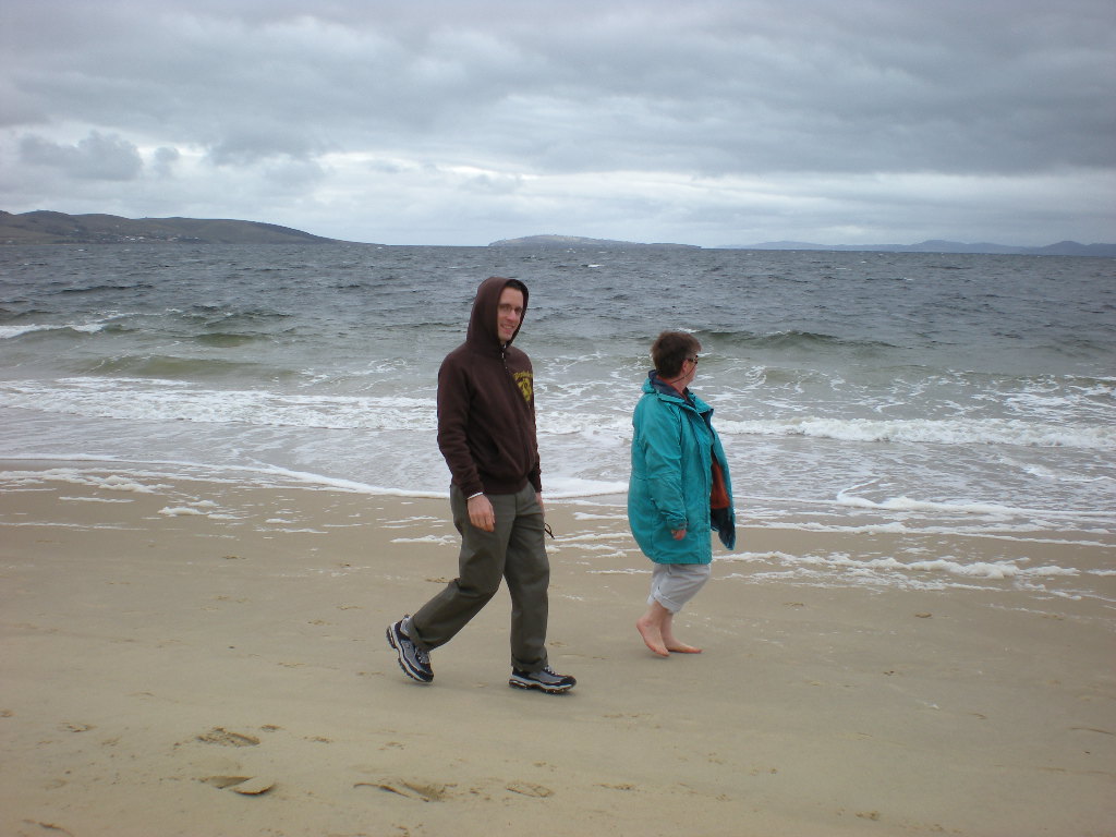 a man standing next to a woman on a beach