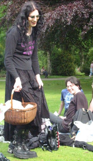 a woman holds her basket with two people lounging behind her