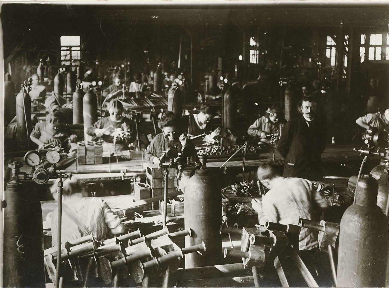 vintage factory scene of various people and machinery