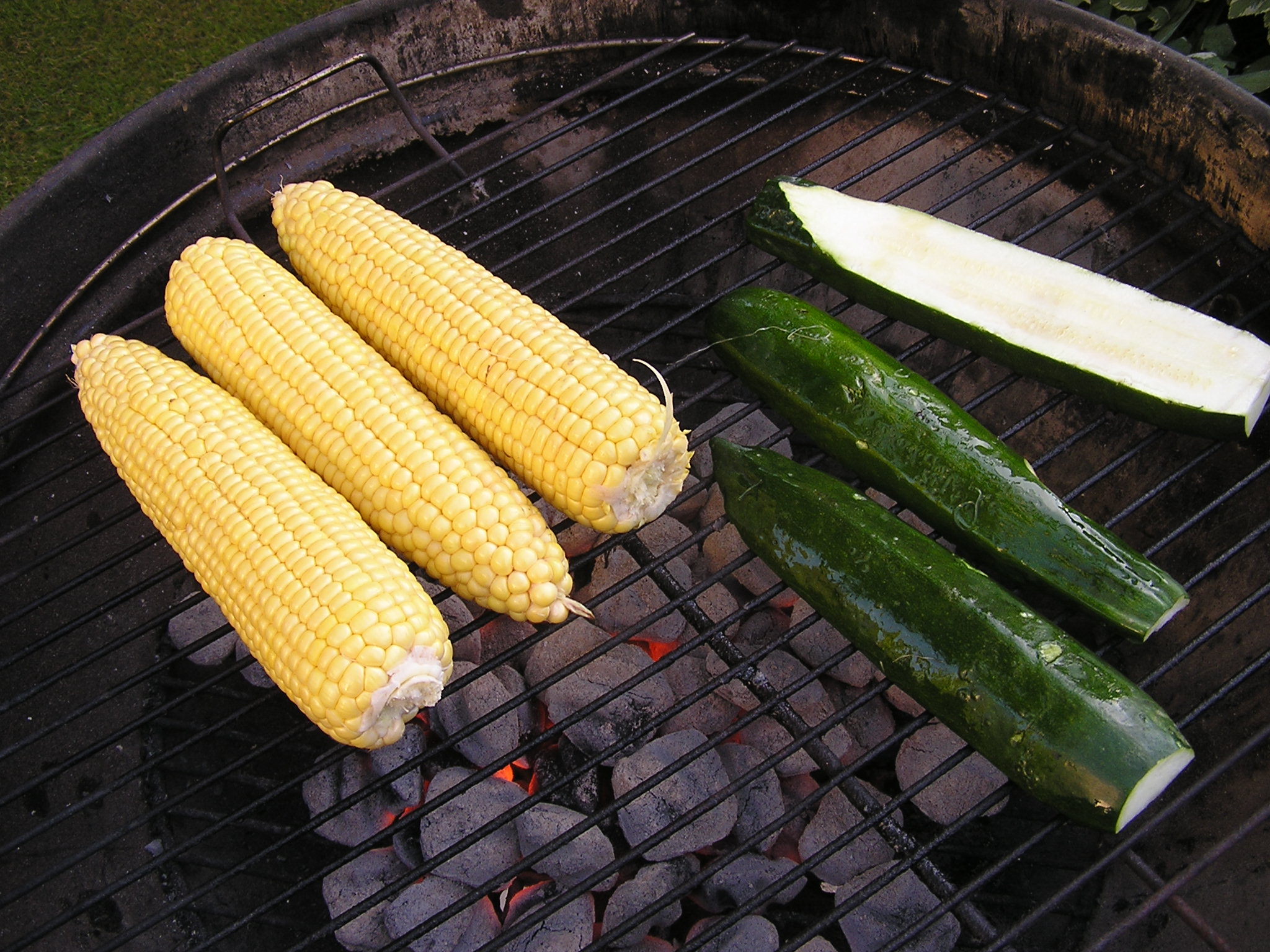 the corn and zucchini are on the barbecue grill