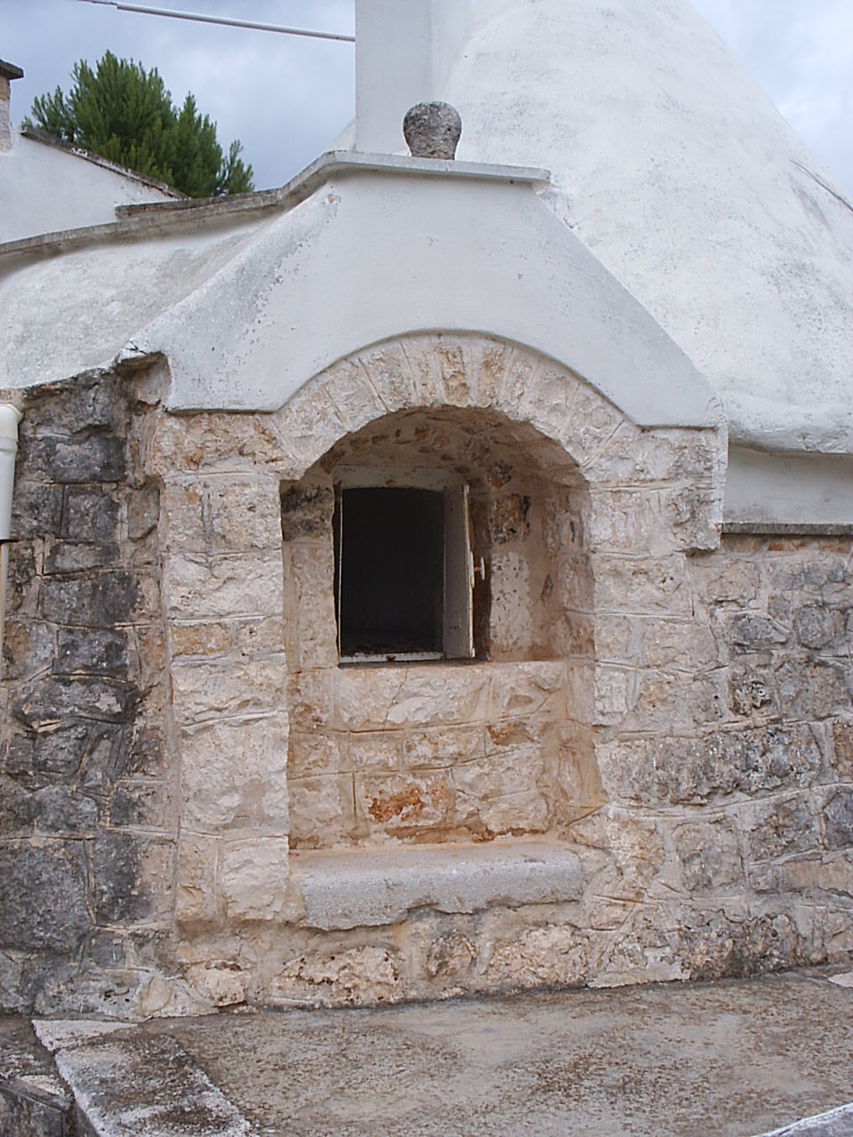 an outdoor shelter with a stone built in window