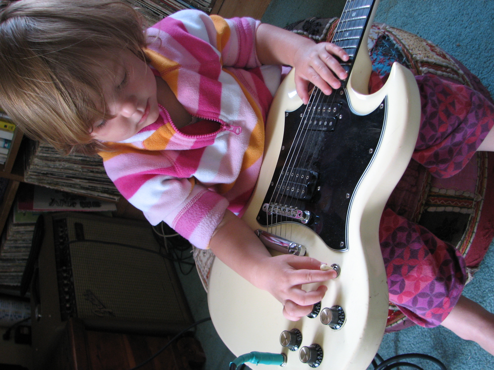 a  playing with her toy guitar