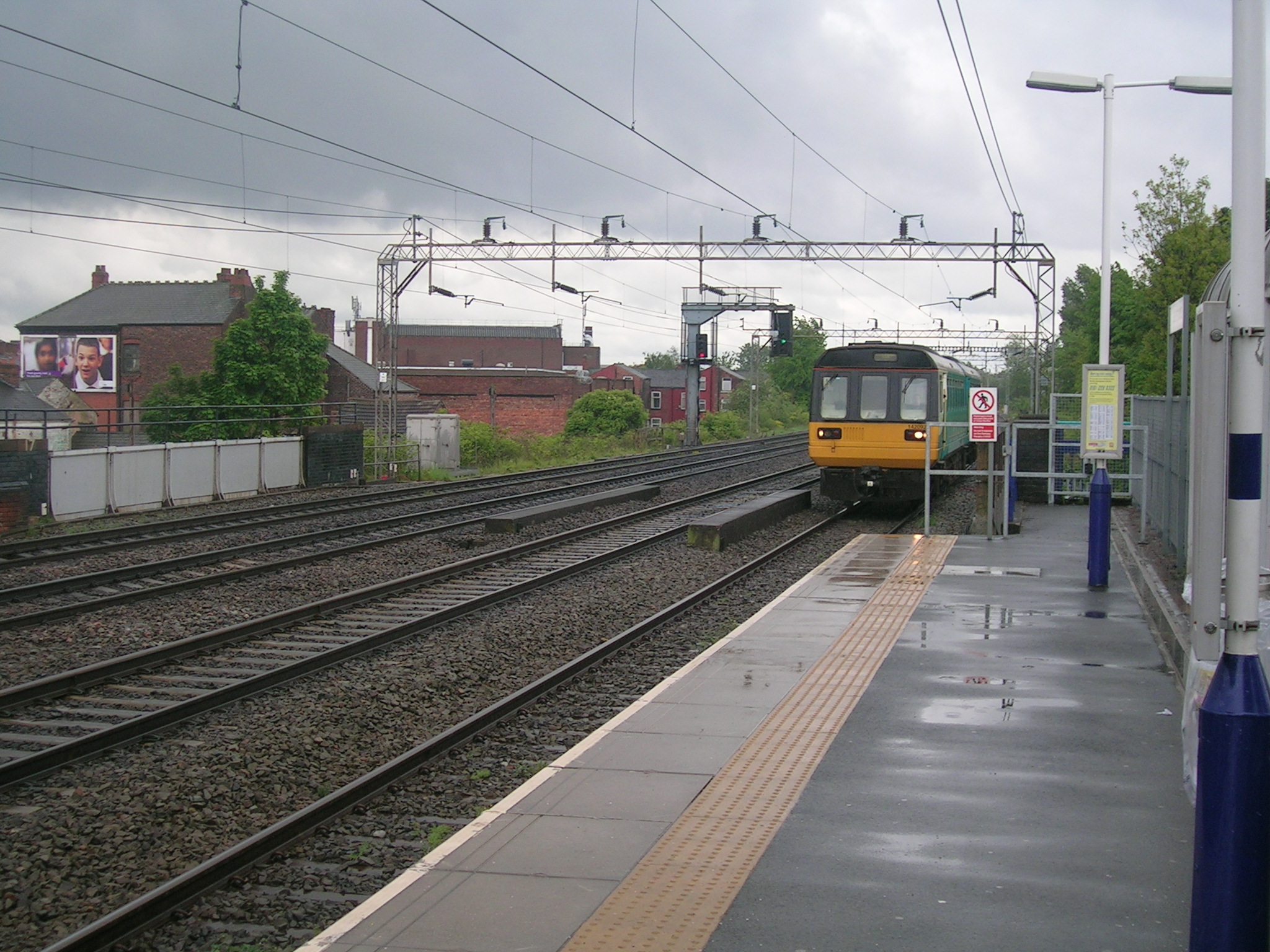 an orange and white train is traveling down some tracks