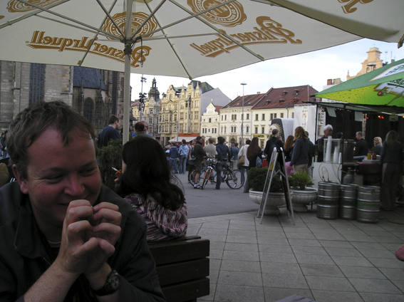 a man sits under an umbrella in front of a crowd