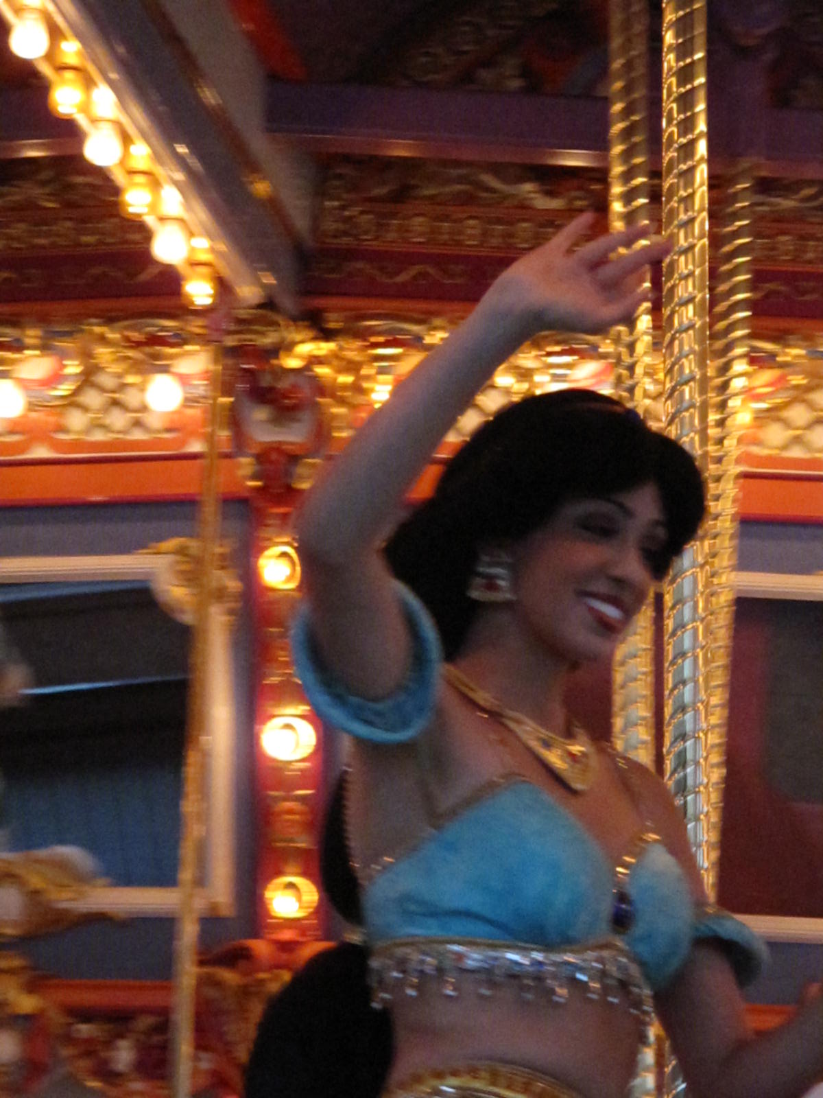 a woman on a carousel waving to a crowd