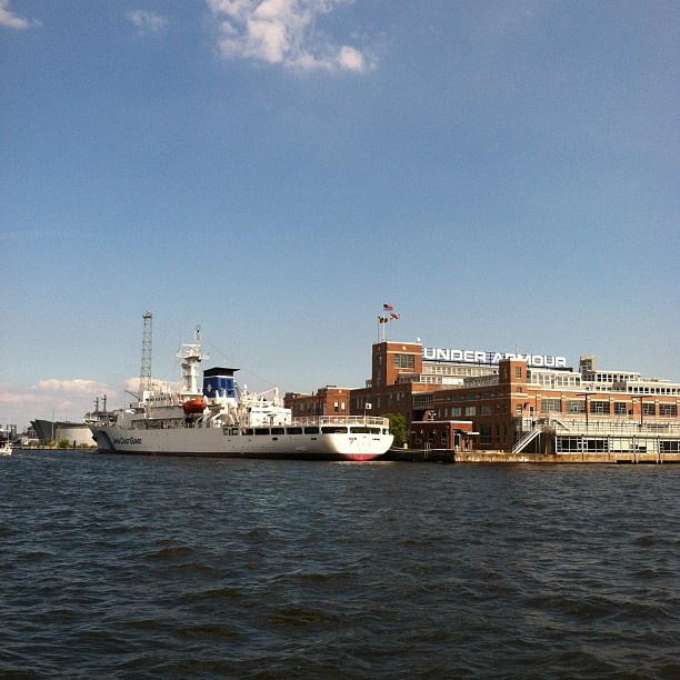 large ferry boat sitting in the water in front of industrial area