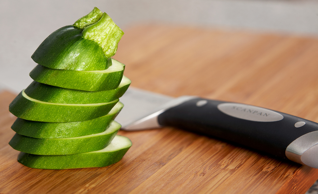 green vegetables are arranged with a knife on the  board