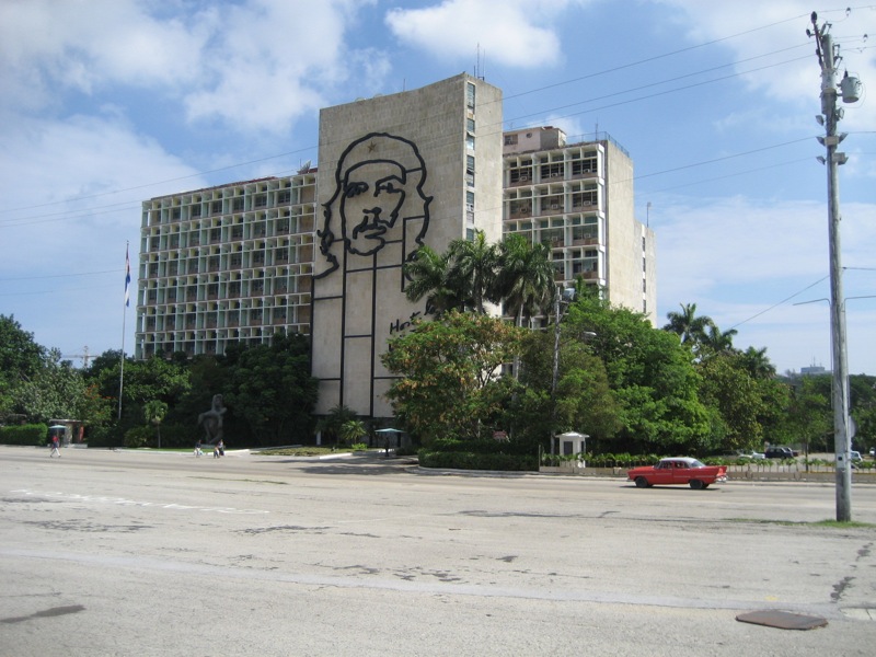 a car passes by a building with a large face on the side