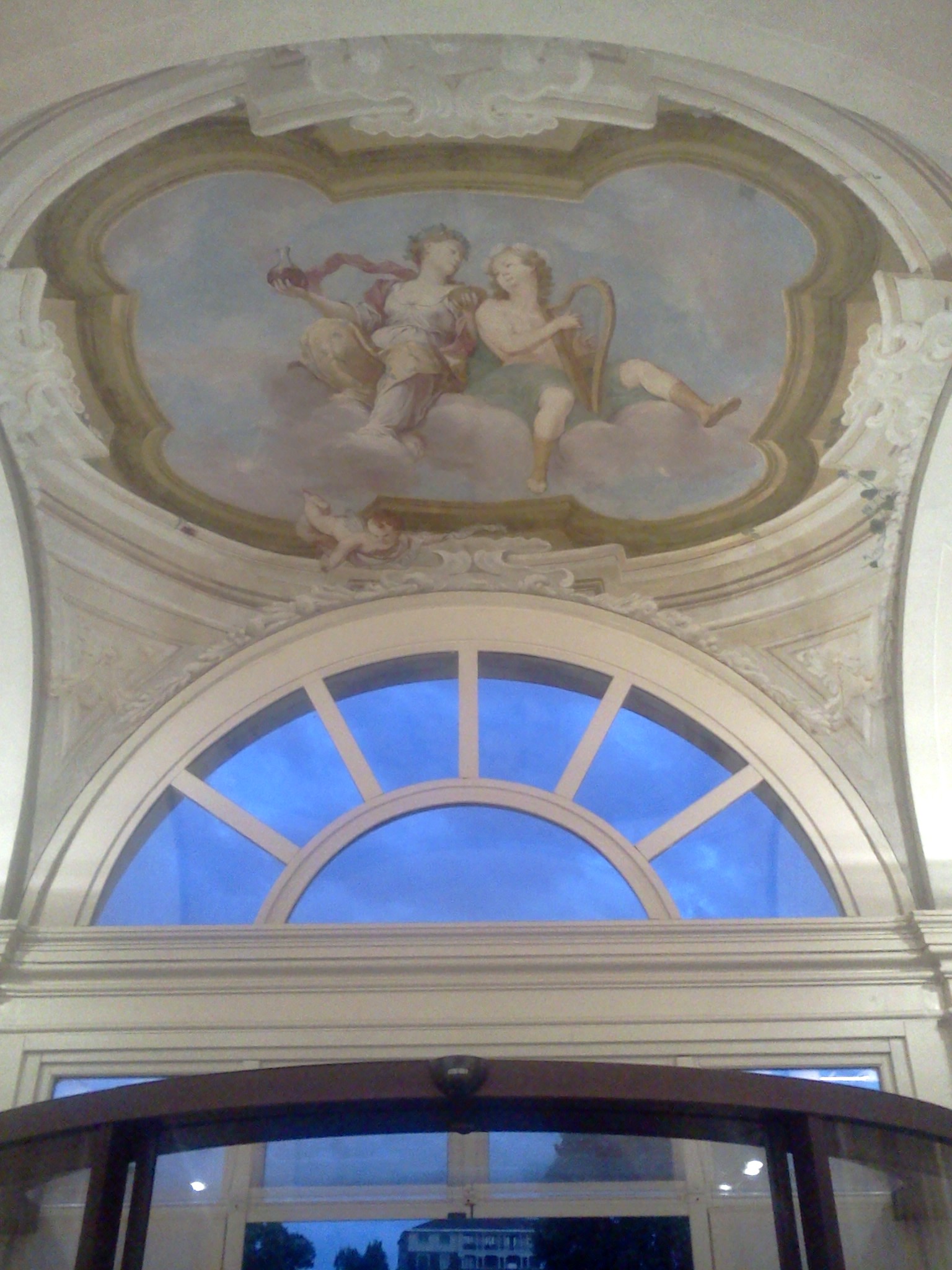the entrance area of a building with a view of two sculptures on the ceiling