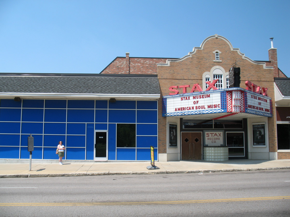 a movie theater sits empty outside of a blue building