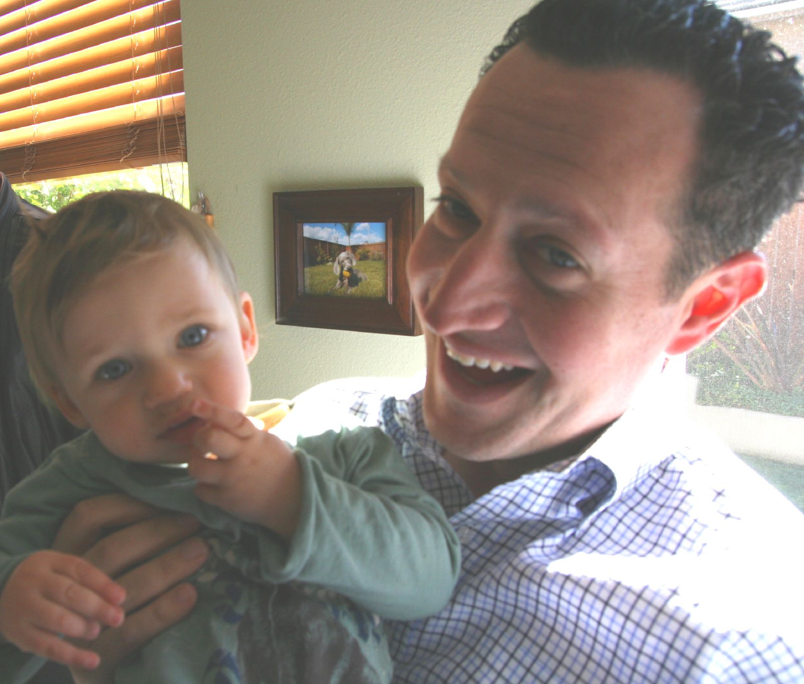 a man holding a little boy with food in his mouth