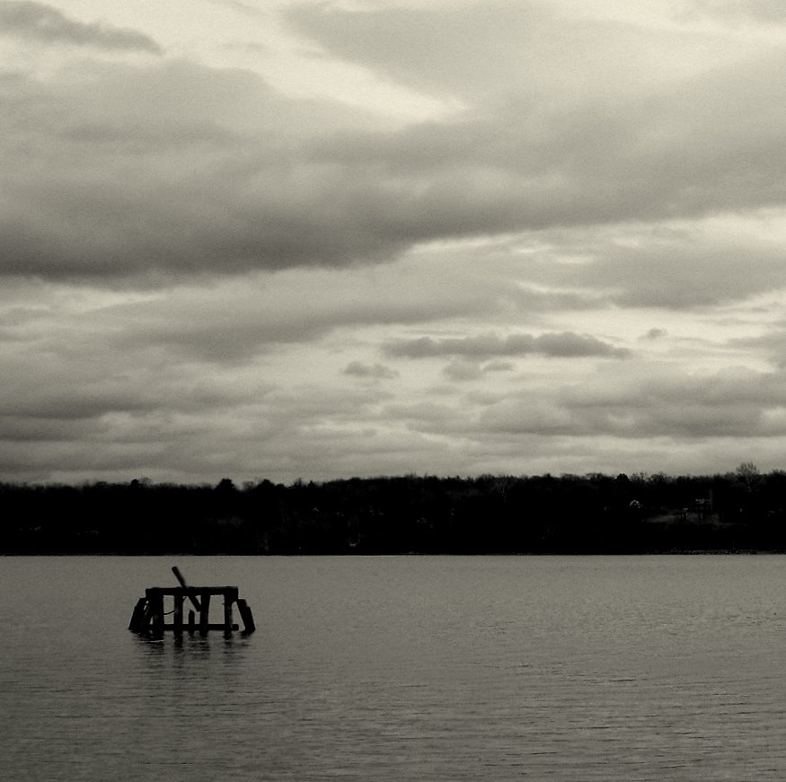 the boat is docked in the lake by the shore