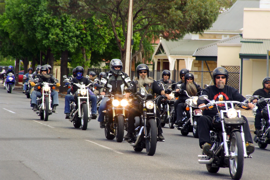 group of motorcyclists riding down the street in traffic