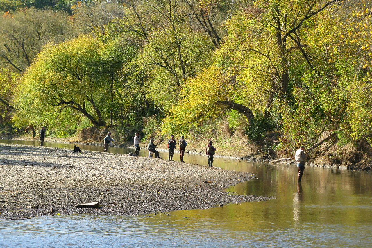 there are people walking along the banks of the water