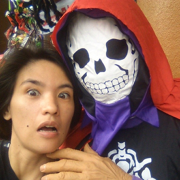 a girl poses with a fake skeleton in front of her