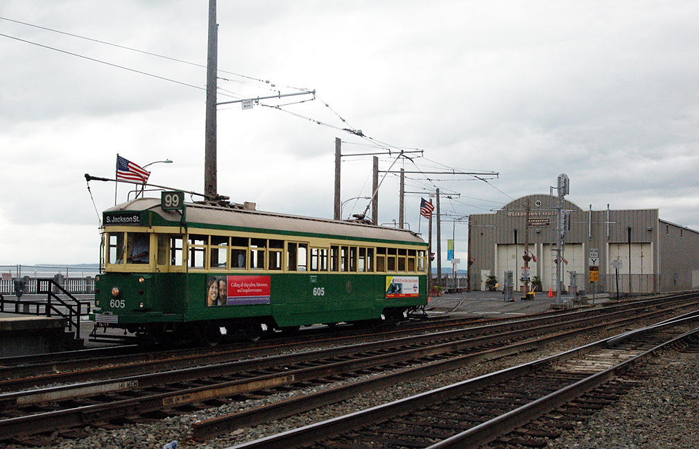 a green and yellow train is on the tracks