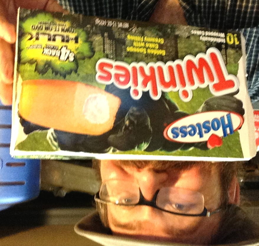 a man is holding up a box of twinkies
