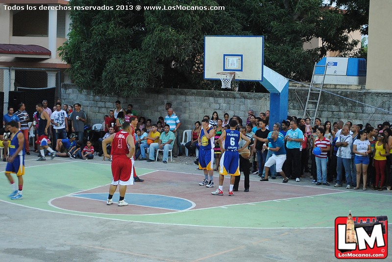 people standing on a court playing basketball in front of a crowd