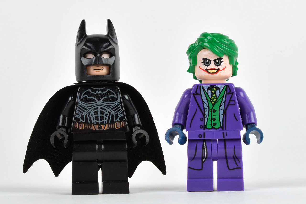 two lego batman minifigures standing next to each other