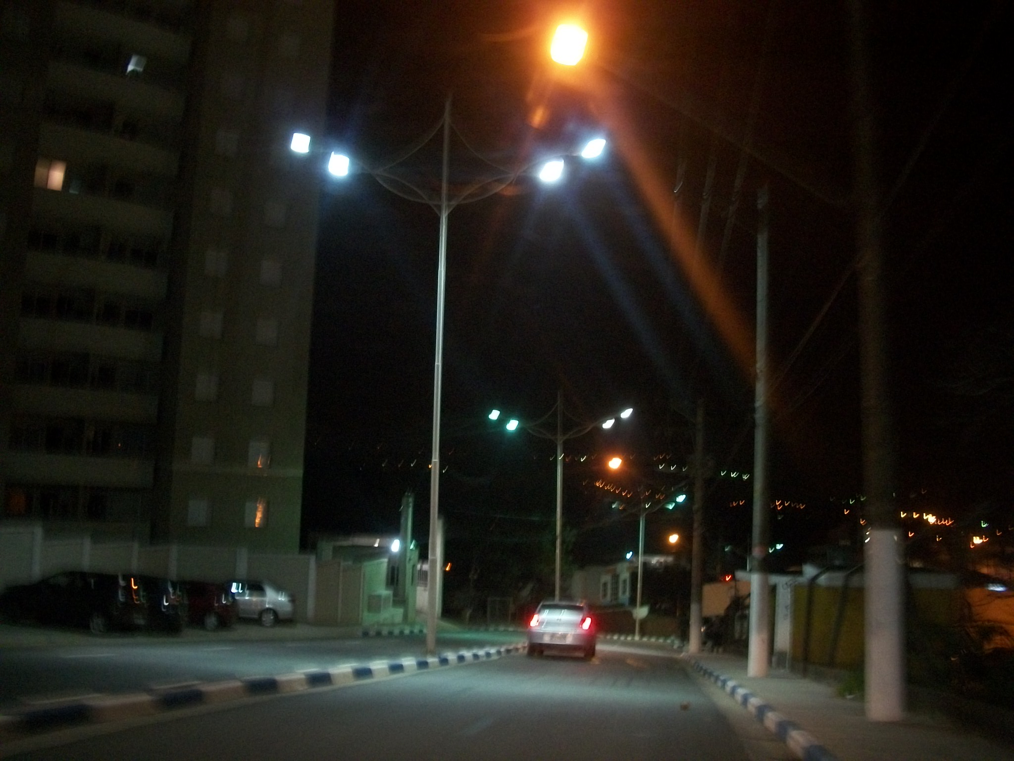 an orange car sits in the middle of an empty street