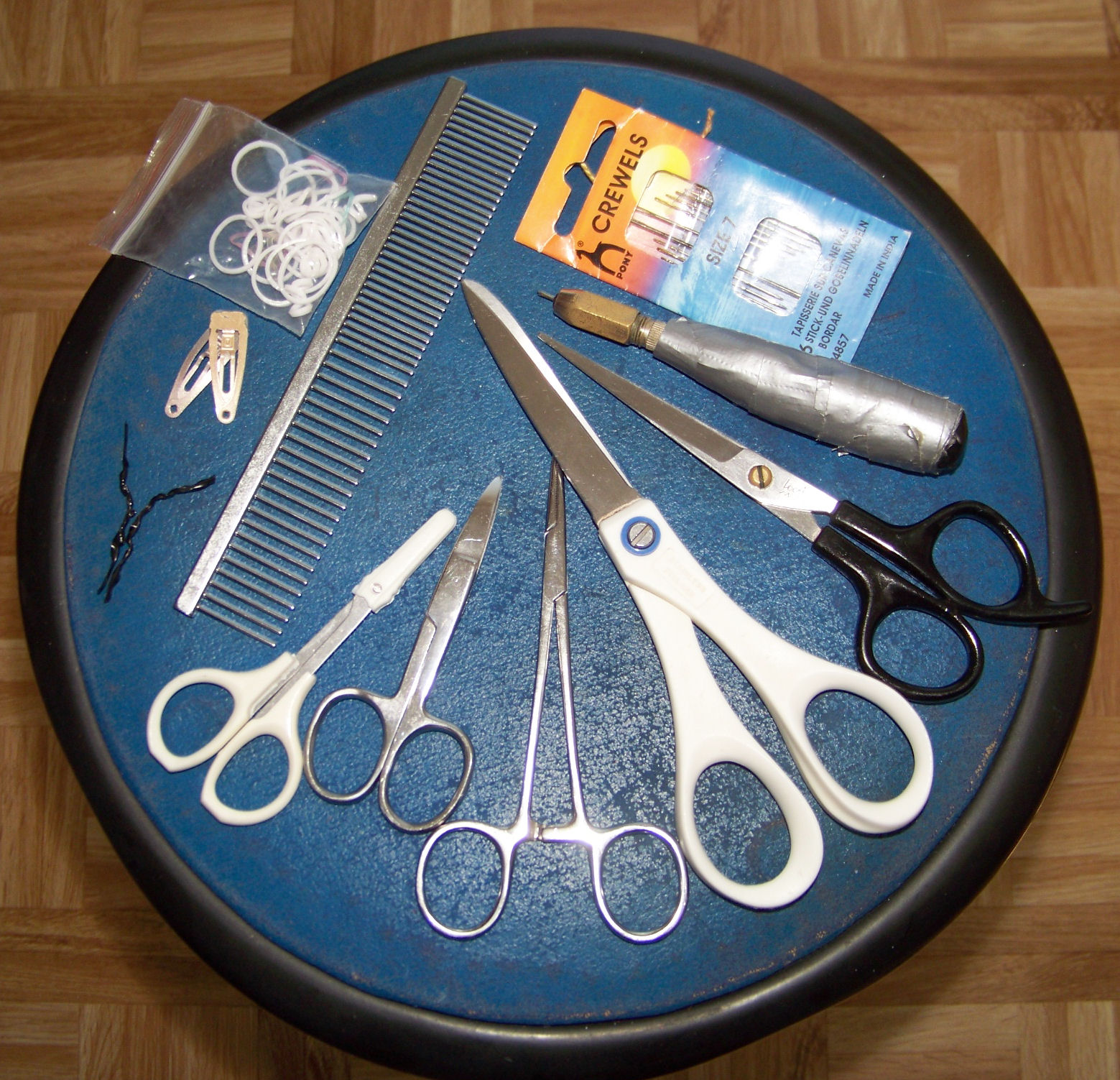 a wooden table topped with pairs of scissors and comb