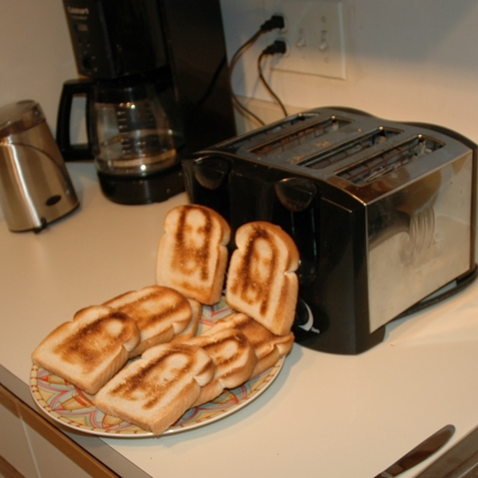 toaster toasted bread on a plate on a counter with a knife