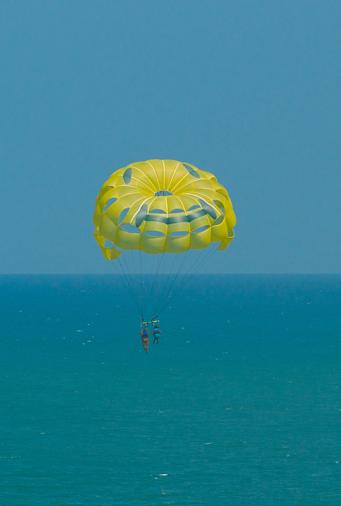 people parasailing with a big green sail in the distance