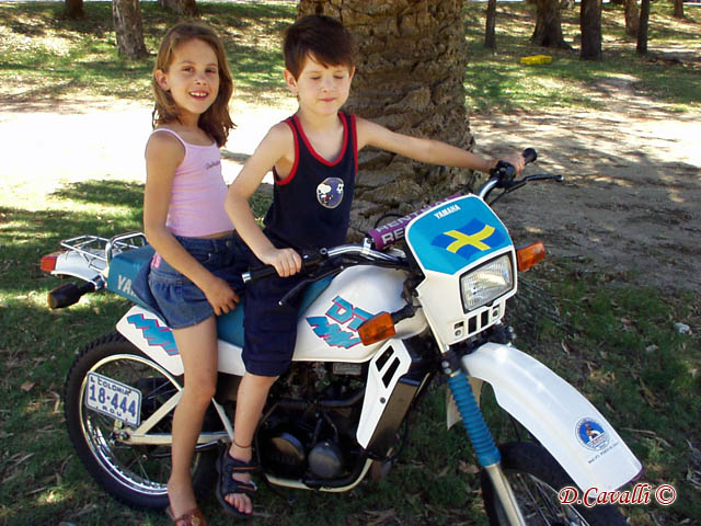 there is a boy and girl sitting on the motor cycle