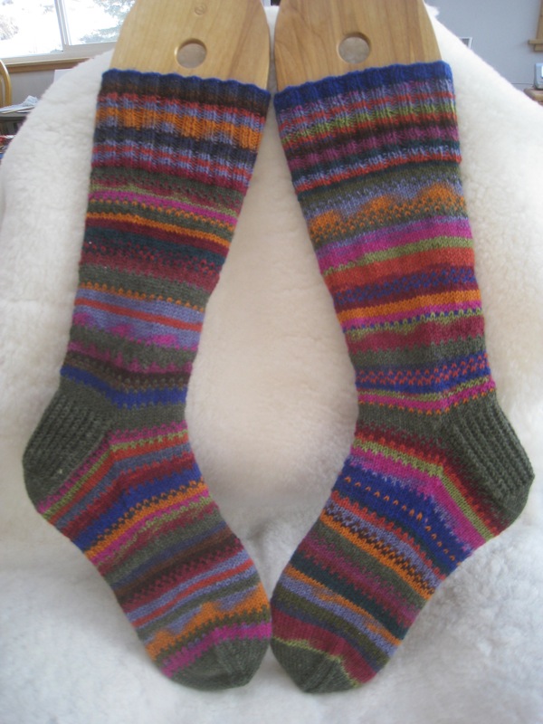 two pairs of colorful knitted socks hang from a rack