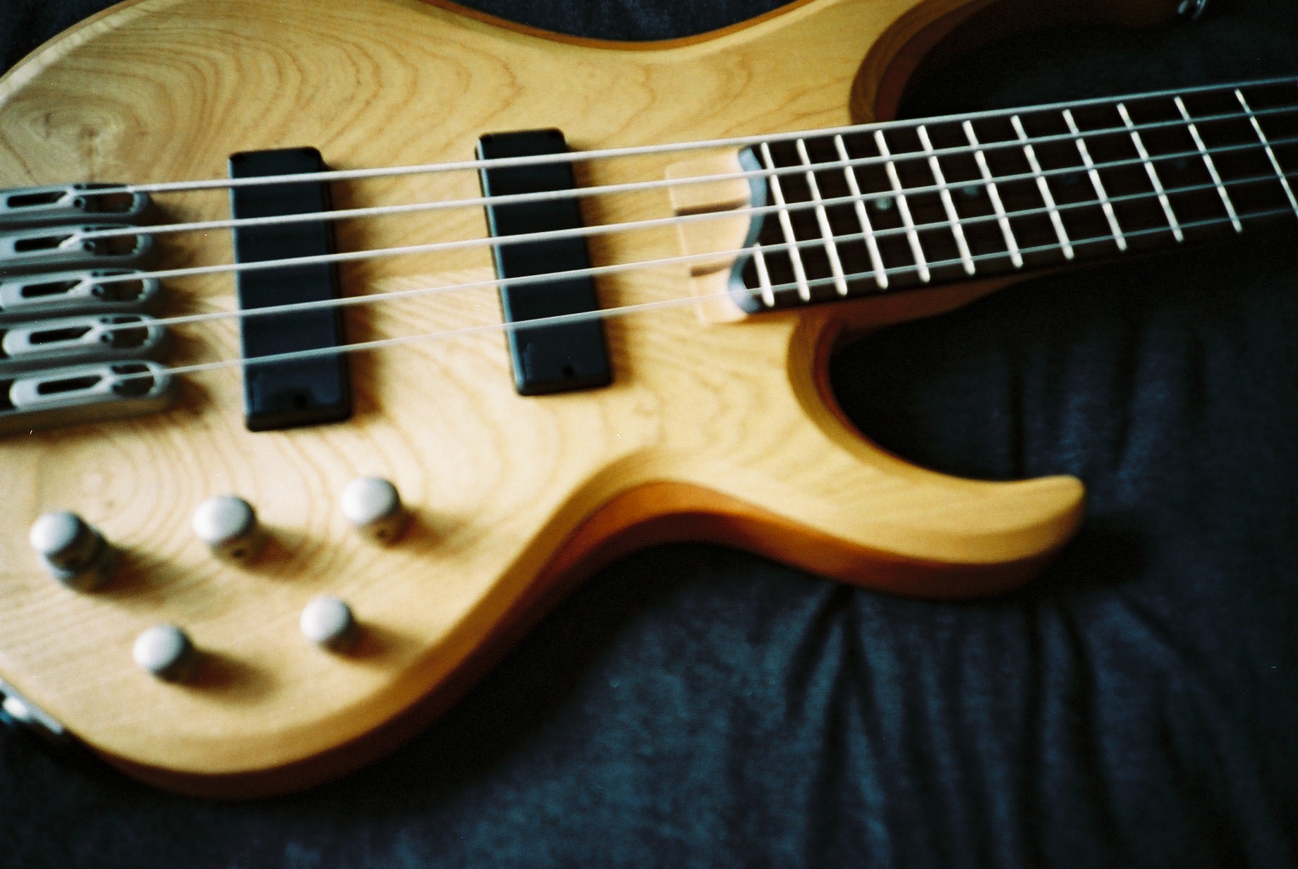 a bass guitar that is laying on a black cloth